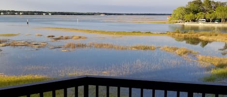 A balcony with a view of a water body and distant shoreline.