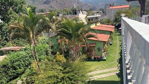 A residential area with a well-maintained lawn, a white table, and a stone wall. - Hotel Posada Kamol Bey (Panajachel)