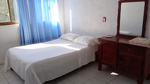 A simple room with a bed, a dresser, and a mirror. - Depto. con alberca, Aire Acondicionado y cerca de Carrizalillo, hasta 6 personas (Puerto Escondido)
