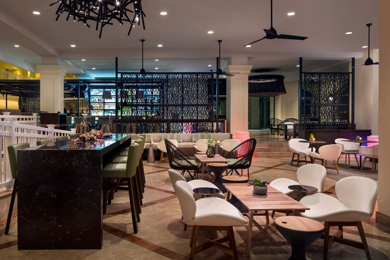A modern interior with a bar area, seating arrangements, and decorative lighting.