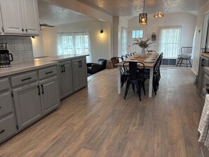 Eine moderne Küche mit grauen Schränken, einem Holztisch und schwarzen Stühlen.