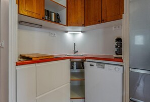 A compact kitchen with a dishwasher, a sink, and wooden cabinets. - 40m from ski slopes, fitness, swimming pool, sauna, balcony, tv, ski locker, 43m², Les Orres (Les Orres)