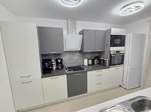 A modern kitchen with grey cabinets, a built-in oven, and a stainless steel sink. - Two Bedroom Apartment Lux 3 with Sea View (Okrug Gornji)