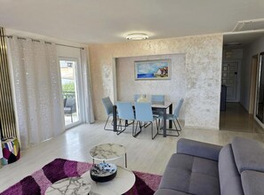 A spacious living area with a dining table, chairs, a sofa, and a coffee table. - Two Bedroom Apartment Lux 3 with Sea View (Okrug Gornji)