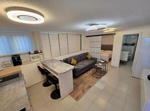 A compact living space with a kitchenette, a sofa, and a dining area. - One Bedroom Apartment Lux 1 with Teracce (Okrug Gornji)