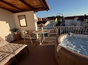 A balcony with a hot tub, a dining table, and a sofa. - One Bedroom Apartment with Sea View and Hydromassage Bath (Vodice)