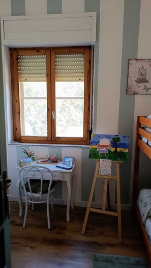 A room with a desk, a chair, a window with blinds, a bunk bed, and a painting on the wall. - Elegant vacation home in the Gulf of Asinara, ideal for families. (Sorso)