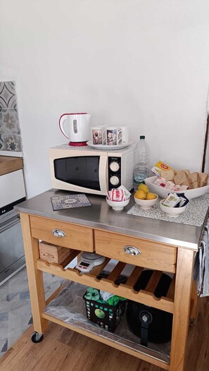 A kitchenette with a microwave, kettle, and a small cabinet with drawers. - Elegant vacation home in the Gulf of Asinara, ideal for families. (Sorso)