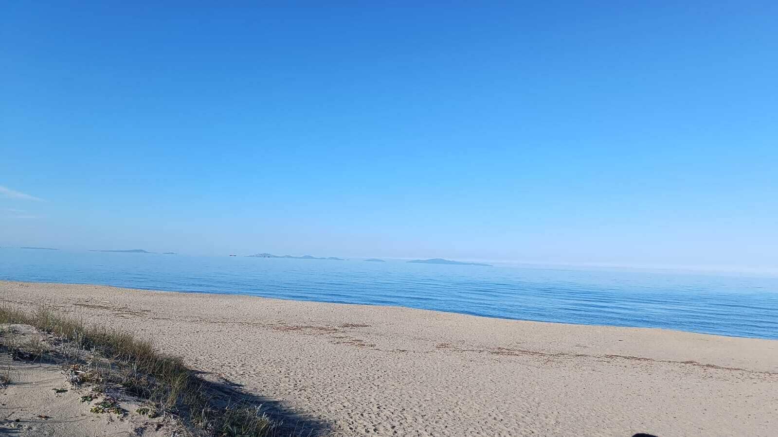 Ein Strand mit blauem Himmel und ruhiger See.