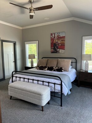 A bedroom with a bed, a ceiling fan, a window with blinds, a nightstand, and a painting on the wall. - Spacious 4-bedroom house in perfect Murfreesboro with AC (Murfreesboro)