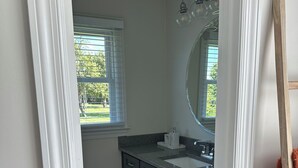 A bathroom with a window, a sink, and a mirror. - Spacious 4-bedroom house in perfect Murfreesboro with AC (Murfreesboro)