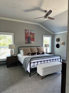A bedroom with a bed, a nightstand, a lamp, a ceiling fan, and a window with blinds. - Spacious 4-bedroom house in perfect Murfreesboro with AC (Murfreesboro)
