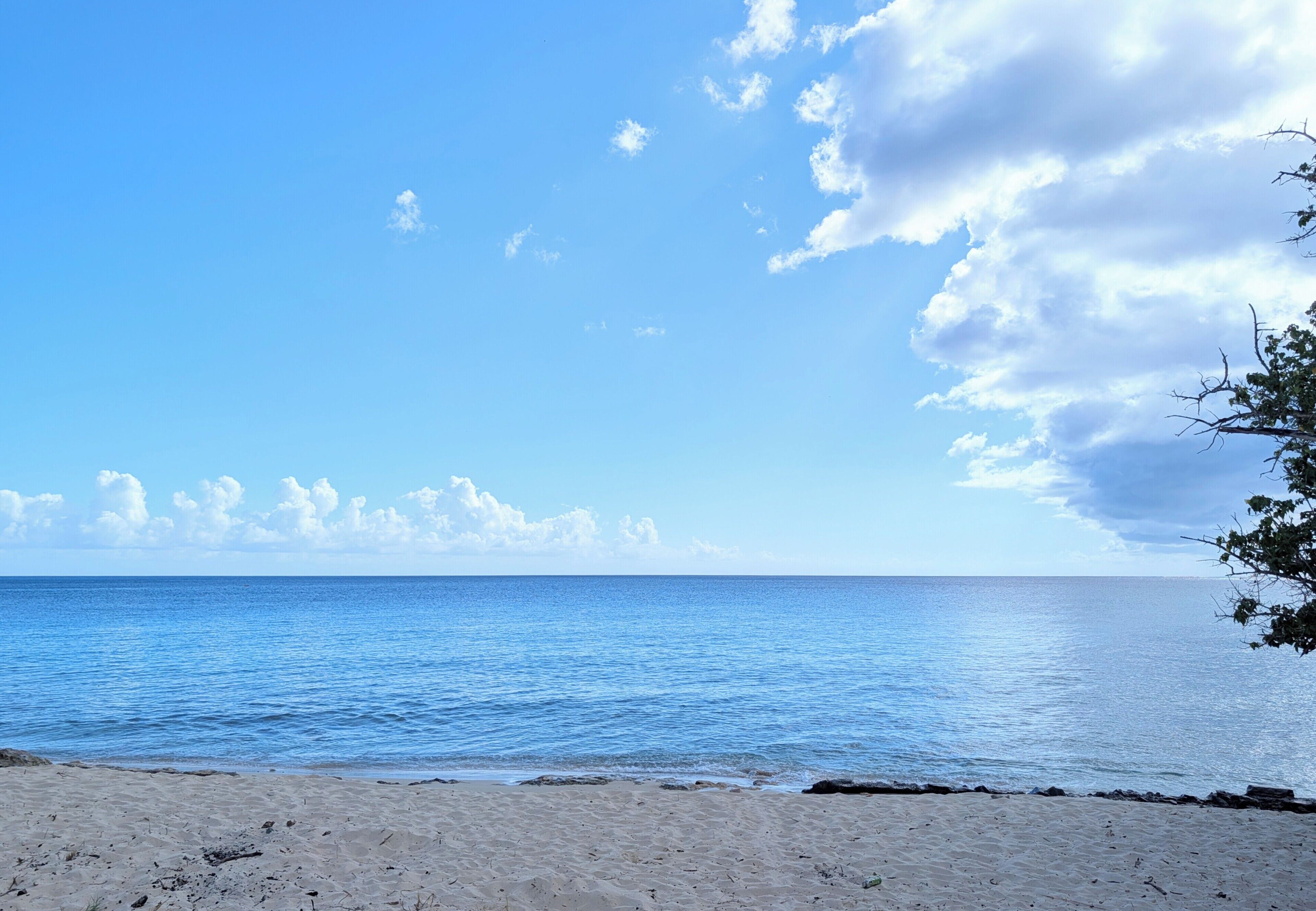 Une plage avec un ciel dégagé et une eau calme.