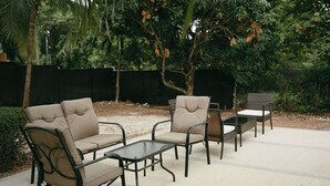 En udendørs patio med loungesæt og et lille bord.