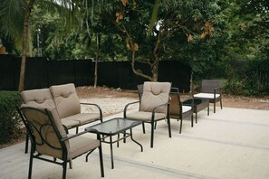 Eine Terrasse im Freien mit einer Sofagarnitur und einem kleinen Tisch.