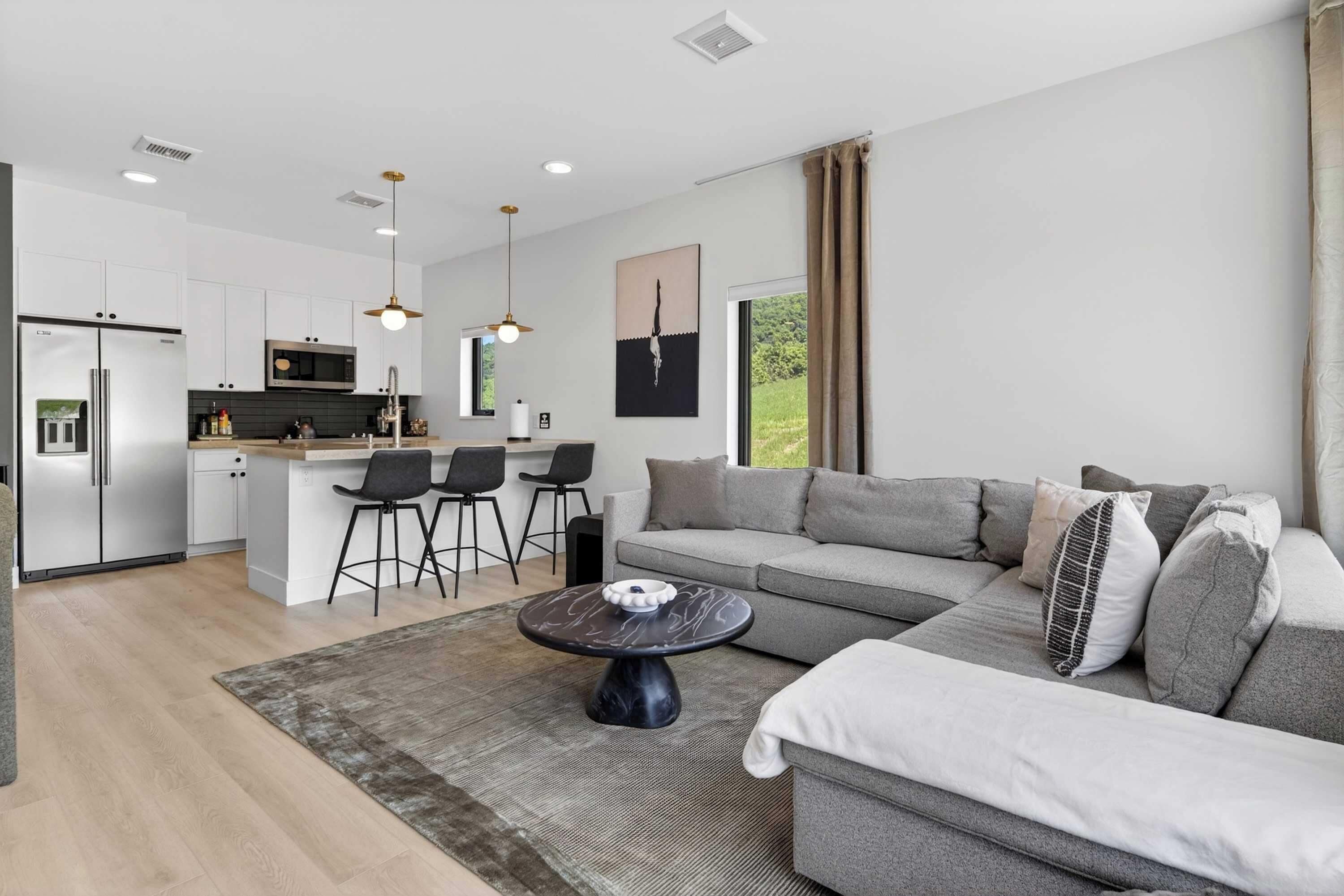 A modern living space with a kitchen, dining area, and seating area.