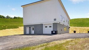 A single-story building with a flat roof, a garage door, and a small attached structure. - The Upstate Loft- Close to Ithaca, Cornell, and IC (Newfield)
