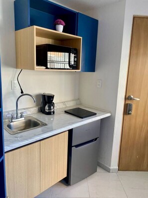 A compact kitchen with a built-in microwave, a coffee maker, and a sink. - Private space in Alameda W/ Kitchenette & bathroom (Santiago de Querétaro)