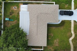 A rooftop with a brick pattern, surrounded by a grassy area and a driveway. - Palm Harbor Retreat  2BR / 2BA Home (Palm Harbor)