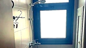 Ein kleines Badezimmer mit Toilette, Dusche und Fenster.