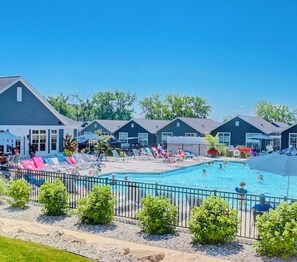 A swimming pool area with lounge chairs and a fenced pool. - Unobstructed Lake Erie Views — Sunrise from the Covered Front Porch (Lakeside Marblehead)