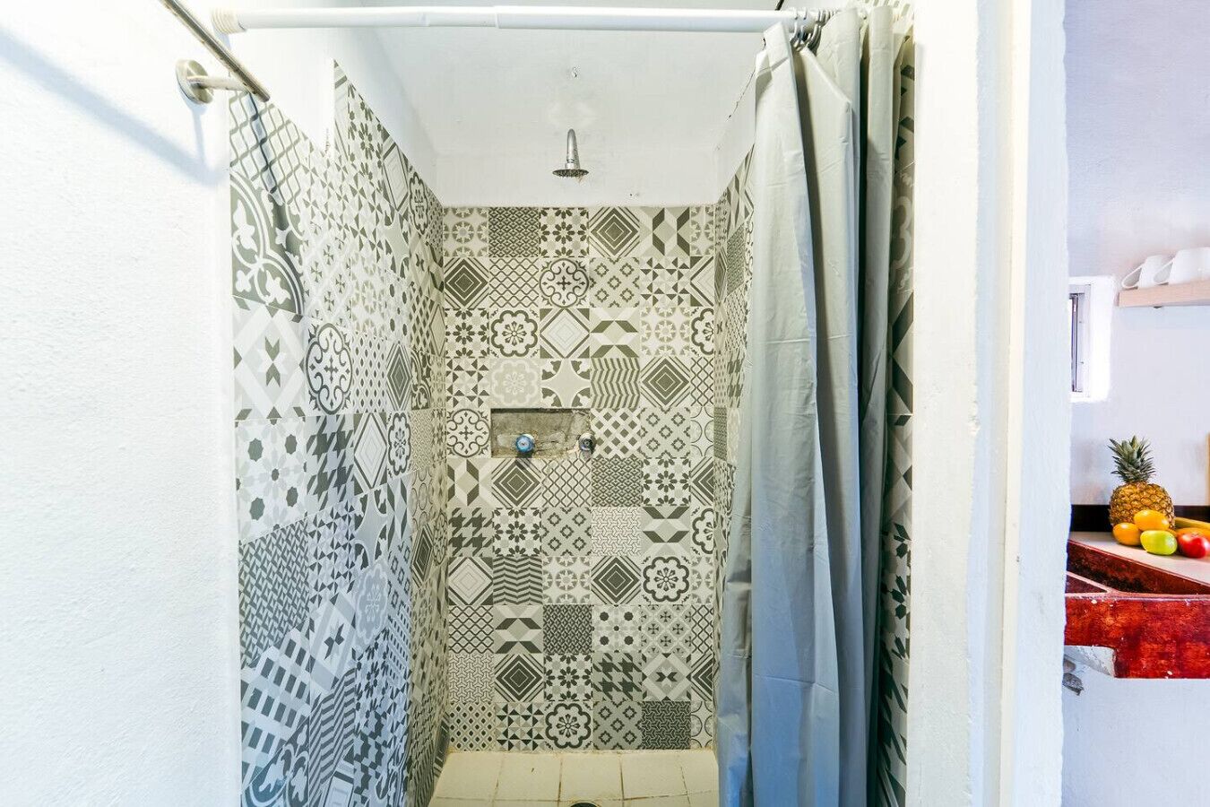 A shower with patterned tiles and a showerhead.