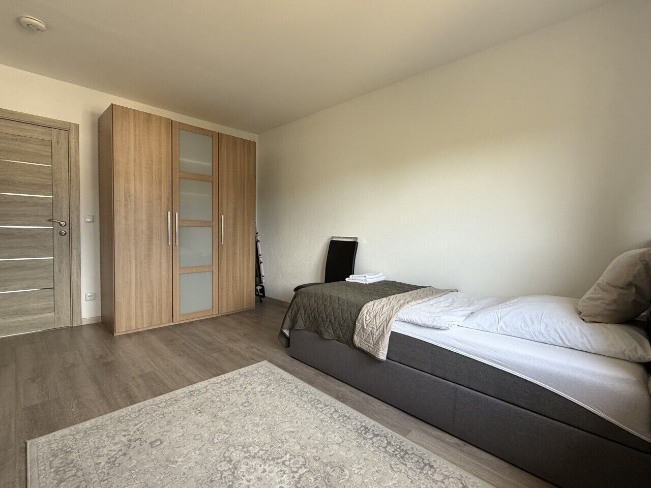 Ein Schlafzimmer mit einem Bett, einem Schrank und einem Nachttisch.