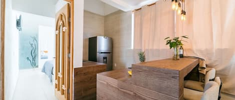 A modern kitchen with a built-in refrigerator, wooden countertops, and a dining area with a bench and chairs.