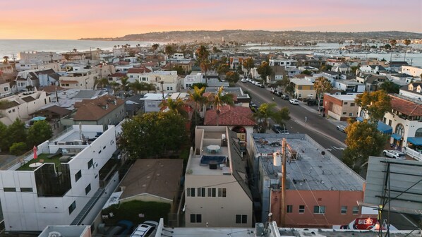 A residential area with a street, houses, and a view of the ocean.