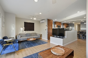 A modern apartment with a living room, kitchen, and dining area.