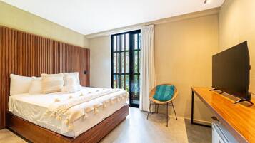 A modern bedroom with a large bed, a television, and a small desk.