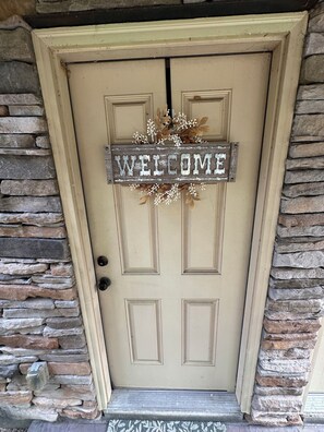 A beige door with a 'WELCOME' sign and a wreath. - Cozy 2-bedroom 2 full bath townhome in Ruston near Tech Campus! (Ruston)