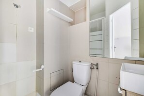 A bathroom with a toilet, a shower, and a sink. - Studio 2P on the Outskirts of Paris (Aubervilliers)