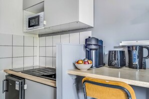 A compact kitchen with a microwave, coffee maker, and toaster on the counter. - Studio 2P on the Outskirts of Paris (Aubervilliers)