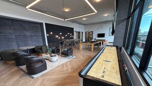 Et moderne loungeområde med billardbord, behagelige siddepladser og et spiseområde.