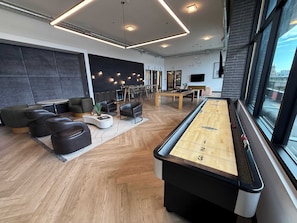 A modern lounge area with a pool table, comfortable seating, and a dining area. - Prime Location Rooftop, Pool, Hot Tub & Gym (Salt Lake City)