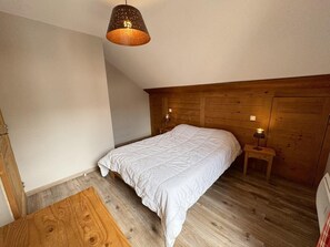 A bedroom with a wooden headboard, a single bed, a bedside table with a lamp, and a wooden floor. - 50m from ski slopes, 4th floor, swimming pool, balcony, ski locker, 45m², Vars (Vars)