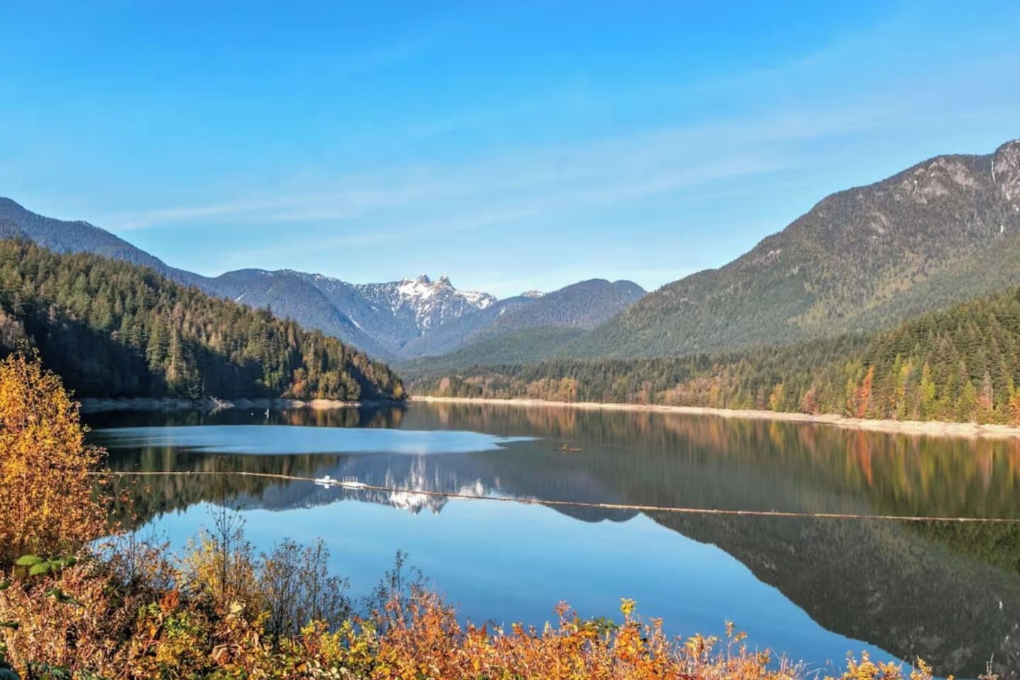 Un lago tranquilo rodeado de montañas boscosas.