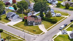 A residential area with houses, a swimming pool, and a road. - Cape May Escape • Sleeps 10 • Tiki Bar • Grill (Cape May)