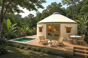 A tent-style accommodation with a pool, outdoor seating, and lush greenery.