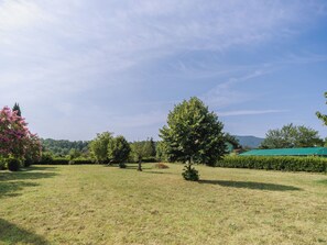 A grassy field with trees and a building in the background. - Gli Oleandri di Grazia by Interhome (Licciana Nardi)