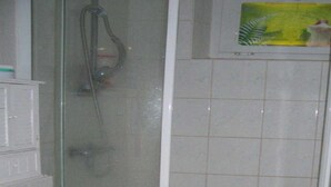 A bathroom with a glass-enclosed shower, a toilet, and a sink. - Hamburg: 3-room apartment, 50 square meters, 3 beds, lodging, vacation rental—including LAST-MINUTE deals (Hamburg)