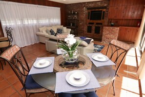 A dining area with a round table set for four, surrounded by chairs. - Historic Pool House on 4-acre Mango Farm in heart of Miami-Reduced this Summer (Miami)