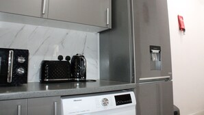 A kitchen with a stainless steel refrigerator, a Hisense dishwasher, and a coffee maker on the countertop. - Stylish Bradford Home | Near City Centre | Sleeps 11 (Bradford)