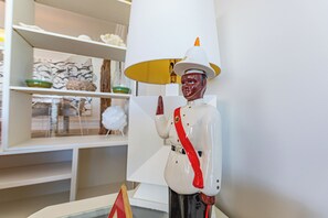 A statue of a figure in a white uniform with a red sash, standing in front of a white lamp. - Caprice 5 - 3BR Oceanfront Villa + Pool (Nassau)