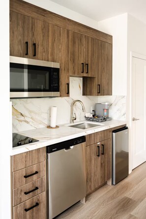 Eine moderne Küche mit Holzausstattung, Edelstahlgeräten und einer Marmor-Spritzschutzwand.