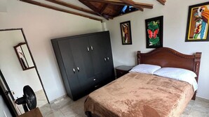 A bedroom with a bed, wardrobe, and a desk with a chair. - Hacienda Familiar - Estancia 30P - Wifi (Ulloa)