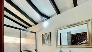 A modern bathroom with a toilet, a shower with frosted glass doors, a vanity with a mirror, and a tiled floor. - Hacienda Familiar - Estancia 30P - Wifi (Ulloa)