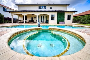 Ein Haus mit großem Pool und einer Terrasse.