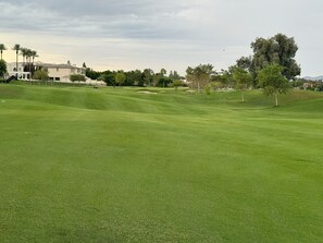 Ein gepflegter Golfplatz mit einem Clubhaus im Hintergrund.